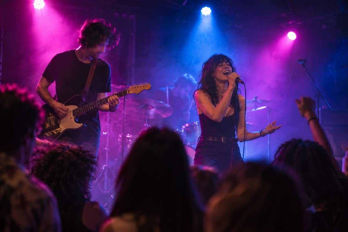 A young band playing under colored stage lights